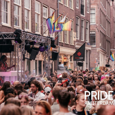 Pride Amsterdam street party with crowds and rainbow flags